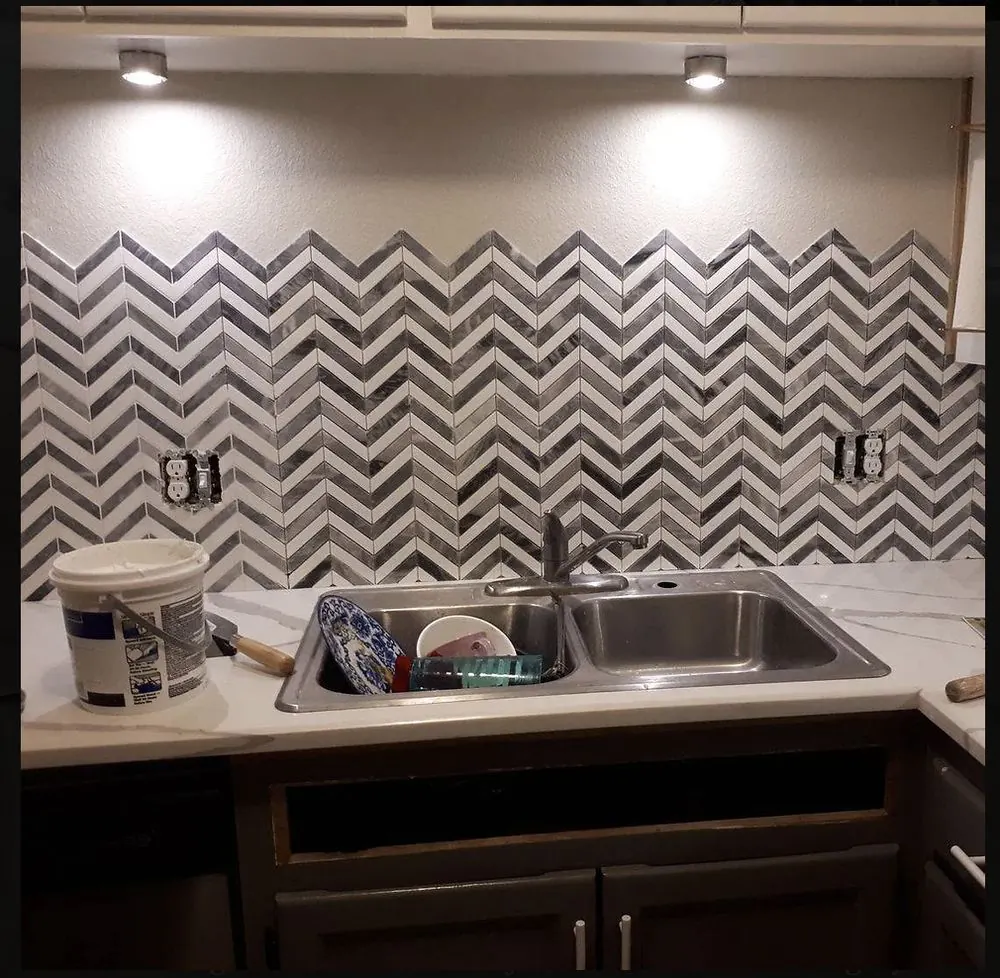 A chevron marble mosaic backsplash with under-cabinet LED lights, mid-install, by Zack